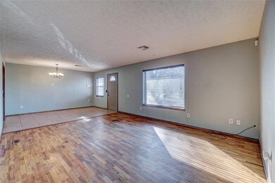 Tiled empty room featuring a textured ceiling and 