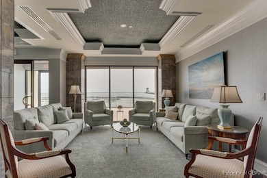 Carpeted living area with ornamental molding and a