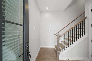 Step inside to a bright and inviting foyer adorned with wide plank hardwood floors, wood stair treads and an elegant wrought iron staircase.