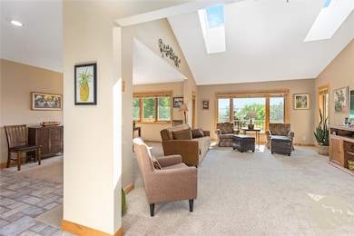 Living room with vaulted ceiling and skylights