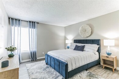 Bedroom with a textured ceiling and light wood-typ