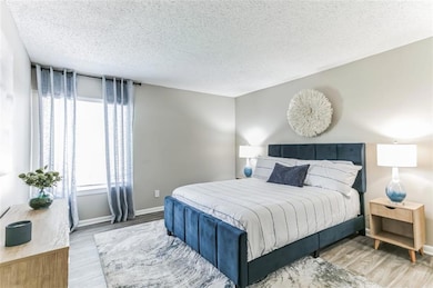 Bedroom with a textured ceiling and light wood-typ