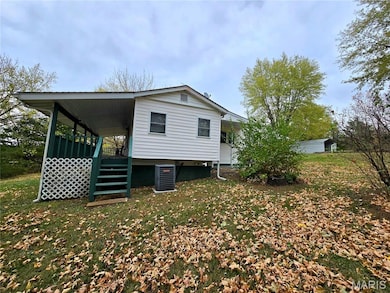 View of property exterior featuring stairway and a lawn