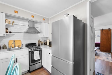 Kitchen featuring a sink, a barn door, wood finish