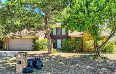 View of front of home with driveway, roof with shingles, brick siding, and an attached garage