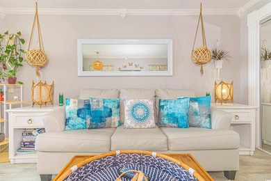 Living room featuring crown molding and a textured