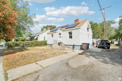 View of side of property featuring solar panels, a chimney, and roof with shingles