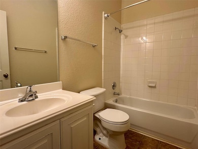 Bathroom with a textured wall, vanity, shower / b