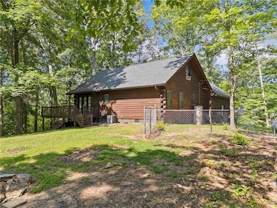 View of side of property with log siding, a wooden deck, and crawl space