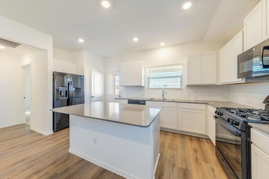 Kitchen featuring black appliances, white cabinet