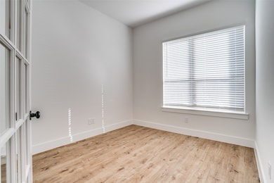 Downstairs office at front of home  with light wood floors.