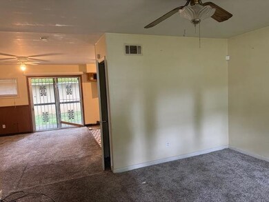 Carpeted empty room with ceiling fan