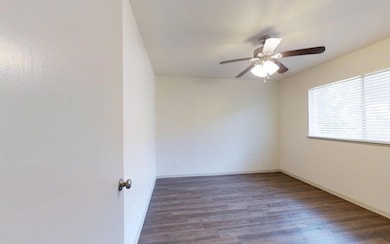 Empty room with ceiling fan and dark wood-type flo