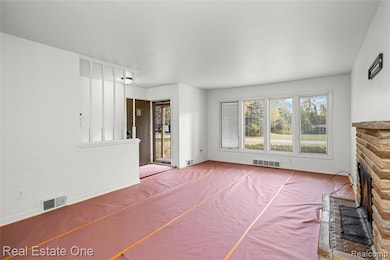 Unfurnished living room with a fireplace with raised hearth and baseboards