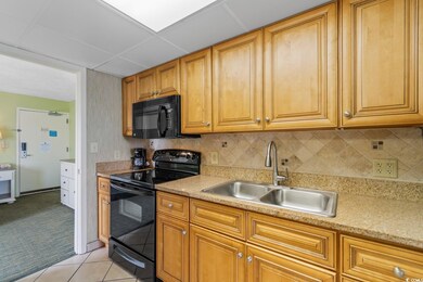 Kitchen featuring a paneled ceiling, light tile fl