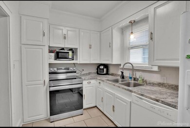 Kitchen with sink, white cabinets, white appliance