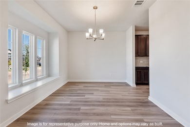 Unfurnished dining area featuring a chandelier and light wood-style flooring