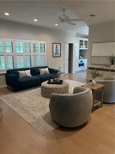 Living area featuring crown molding, light wood-st