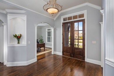 Beautiful double wooden doors, crown molding and arched entryways all add to the luxury of the space