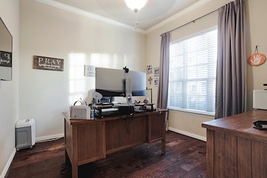 Office space with ornamental molding and dark wood-style flooring