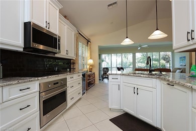 Kitchen with pendant lighting, lofted ceiling, bac