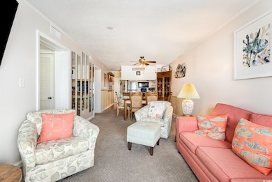 Carpeted living area featuring visible vents, crow