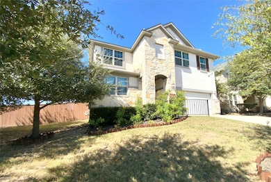 View of front facade with stone siding, an attached garage, driveway, and stucco siding