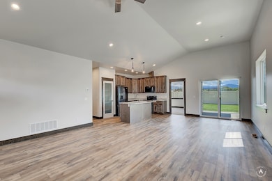 Kitchen featuring open floor plan, light countertops, a kitchen island with sink, light wood-type flooring, and recessed lighting