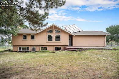 Rear view of house featuring stucco siding and roof with shingles