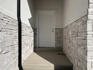Property entrance featuring stone siding and stucco siding