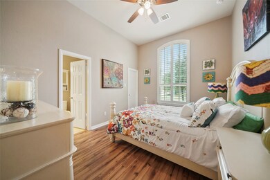 One of the secondary bedrooms with a walk in closet, Jack & Jill bathroom, shutters on the window and a ceiling fan. Gorgeous wood flooring - no carpet!