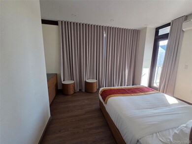 Bedroom featuring dark wood-style flooring and an AC wall unit