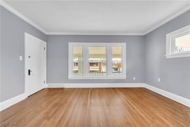 Spare room featuring light hardwood / wood-style floors and crown molding