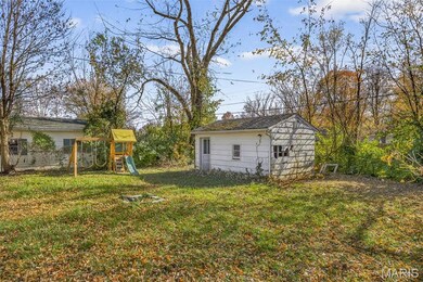 View of green lawn with a playground and an outdoor structure