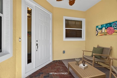 Property entrance with a patio, stucco siding, and ceiling fan