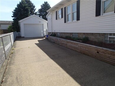 A one car detached garage and paved driveway for a