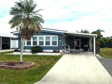 View of front facade with a carport, a front yard,