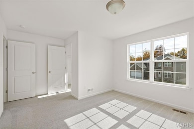 Unfurnished room featuring light carpet and baseboards