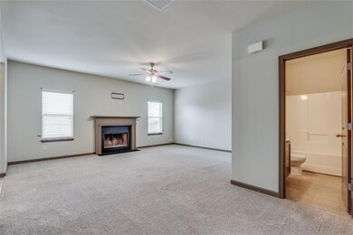 Unfurnished living room featuring light carpet, a ceiling fan, and a fireplace