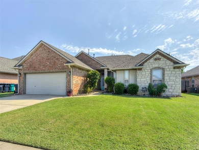 View of front facade featuring a front lawn, concrete driveway, an attached garage, and stone siding