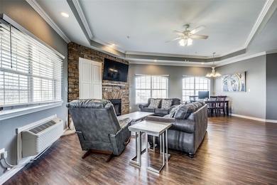 Living room featuring an AC wall unit, a stone fir