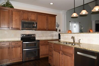 Kitchen with pantry, granite counter-tops, tile back-splash, stainless appliances.