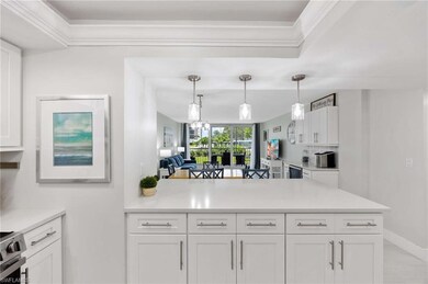 Kitchen featuring stainless steel range with electric cooktop, white cabinets, light countertops, decorative light fixtures, and crown molding