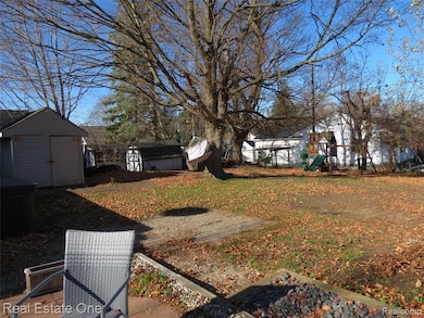Rear yard with shed, patio and playscape.
