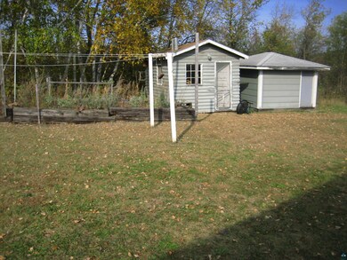 View of yard featuring an outbuilding, a storage shed, and a vegetable garden