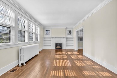 Living room with crown molding, a brick fireplace,