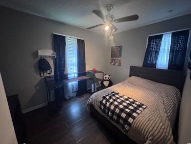 Bedroom featuring wood finished floors, a ceiling fan, and baseboards