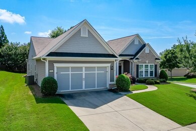 View of front of home featuring concrete driveway, an attached garage, a front lawn, and a standing seam roof