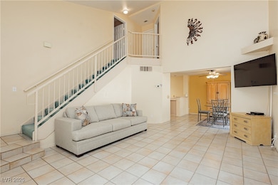 Living area featuring stairway, a high ceiling, ce