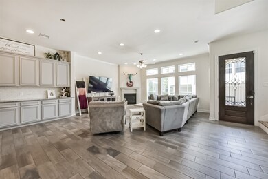 Living room open to the kitchen features a fire pl